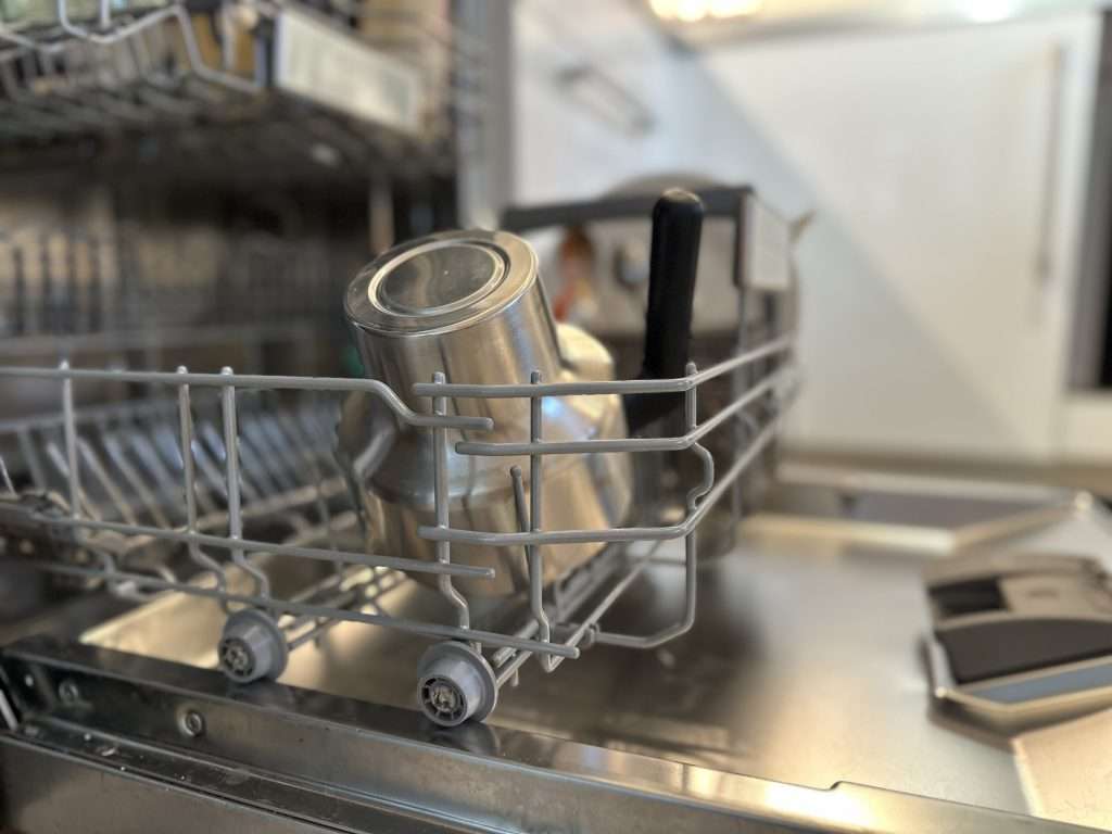 Wasserschaden durch Spülmaschine: Sofortmaßnahmen, Versicherung und Prävention. Offene Spülmaschine mit Geschirr