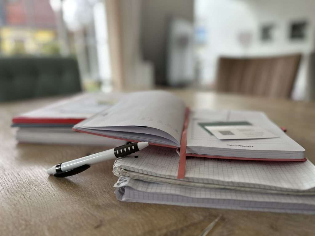 Versicherung zahlt nicht bei Wasserschaden? Wasserschaden, wer zahlt? Tisch mit vielen Dokumenten und Unterlagen. Im Vordergrund liegt ein Kugelschreiber.