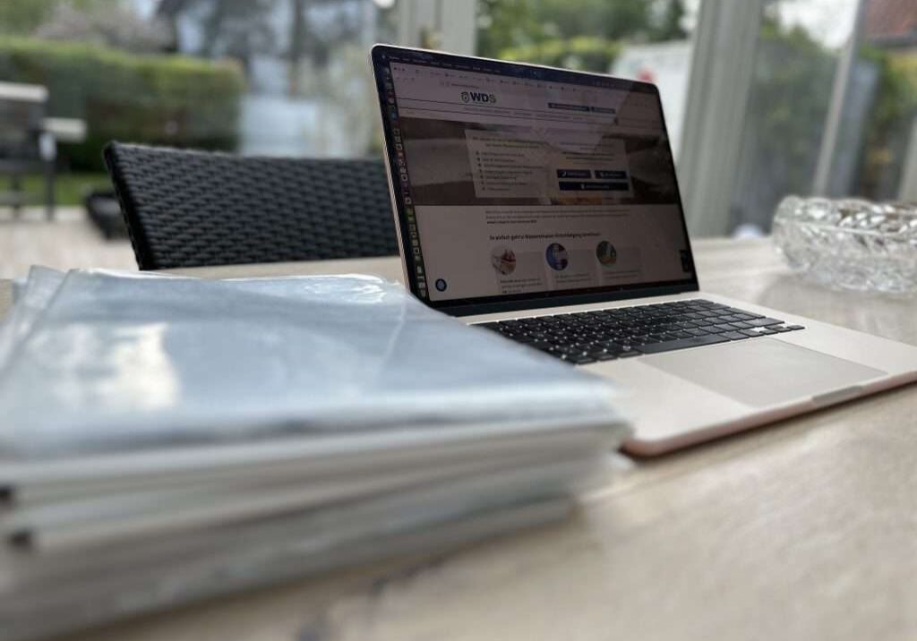 IMG_6455 Versicherungspolicen verstehen – Wie lesen Sie die Policen von Ihrer Versicherung richtig? Laptop mit Wasserschadenshilfe Website geöffnet neben vielen Akten und Papieren