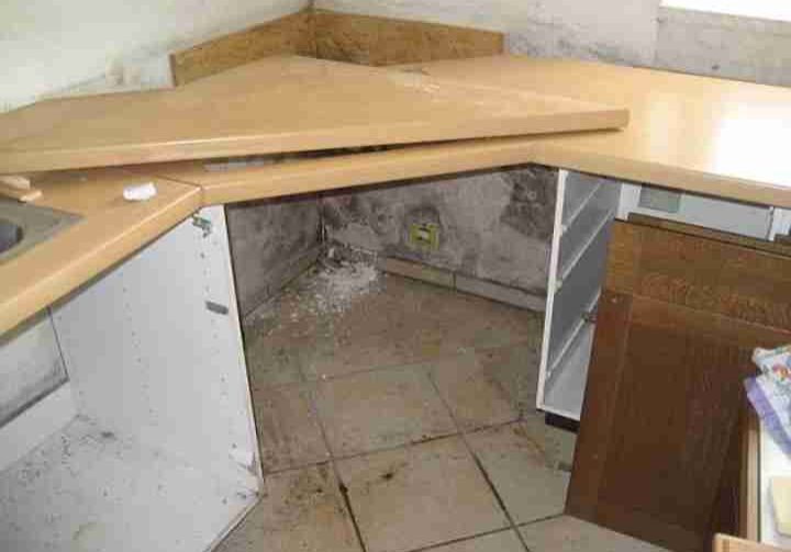 Küche Schaden Wand Eck-Küche mit hellbrauner Arbeitsplatte, die aufgesägt wurde. Dahinter an der Wand ein grauer Schimmel Wasserschaden. Was tun bei Wasserschaden in einer Mietwohnung Bearbeiten Was tun bei Wasserschaden in einer Mietwohnung: Rechte und Pflichten für den Eigentümer